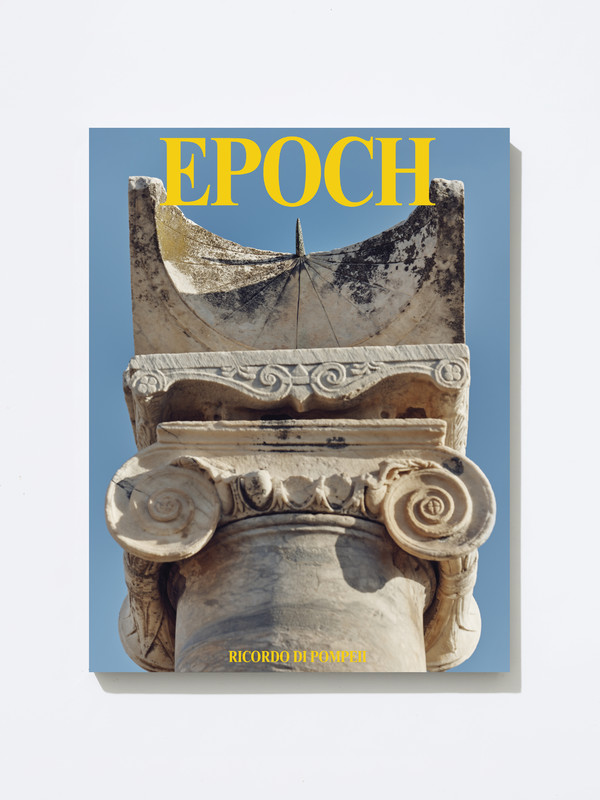 Magazine cover featuring a close-up photograph of an ancient stone Ionic column capital and sundial from Pompeii, shot against a clear blue sky.
